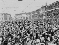 Giovani fascisti, ripresi tra la folla in piazza Vittorio Veneto, sollevano moschetti